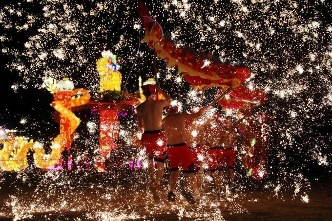 Folk artists perform  a fire dragon dance under a shower of sparks from molten iron in  Shangqiu, Henan province, China, February 14, 2018. Photo by Reuters/Stringer