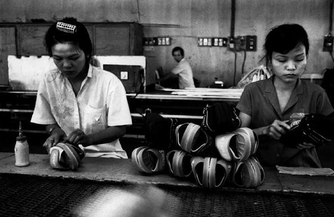 Two women pair sandals in a factory.