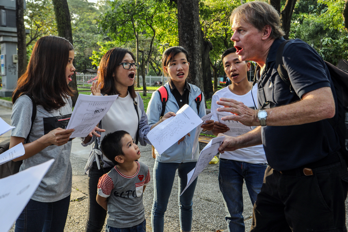 A foreign teacher is teaching English to Vietnamese students of an English center at an open park in HCMC which takes place every Sunday afternoon. Photo by VnExpress/ Thanh Nguyen.