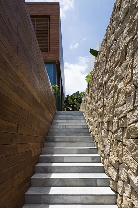 The house has two entrances. The 1st one is under the main part, behind a stony fence. The 2nd one is an exterior staircase running to the higher deck level.