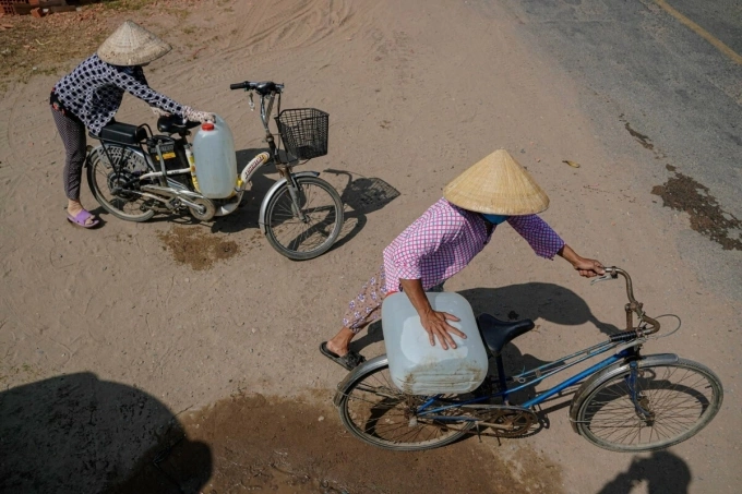 Two women carry water bottles on their bikes.Drought and salinization in the Mekong Delta this year is especially tough, even breaking previous records in 2016. About 40,000 hectares of paddy for the winter-spring period in the Delta have been damaged, and about 95,000 families in the Delta now lack freshwater for daily activities. Five Mekong Delta provinces: Long An, Tien Giang, Ben Tre, Kien Giang and Ca Mau have declared emergency drought states earlier this month.Severe drought and sainization would continue to last until April, experts predicted.