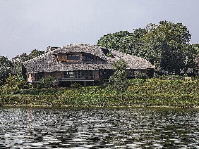 Located in Hanois Son Tay Town, the house lies next to a river and reflects typical northern Vietnamese architecture with wooden furniture and thatched roof. The house is also surrounded by a lot of trees and a river.