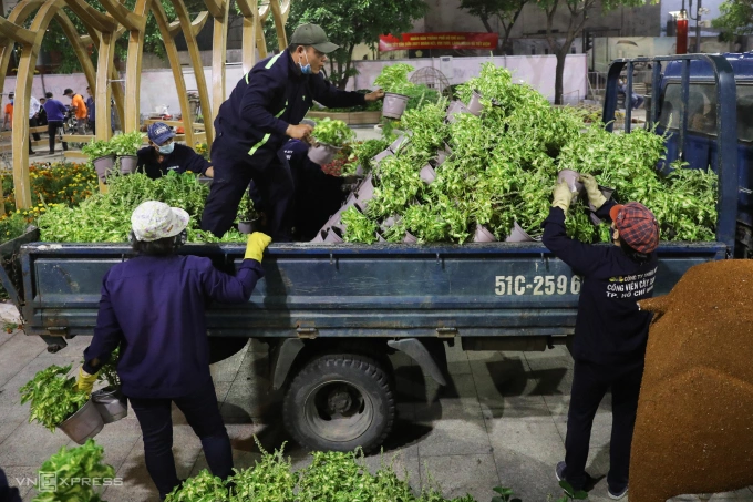Sanitation workers classify flower pots. If those flowers are fresh, they will be stowed into trucks for reuse in parks and tourist areas.