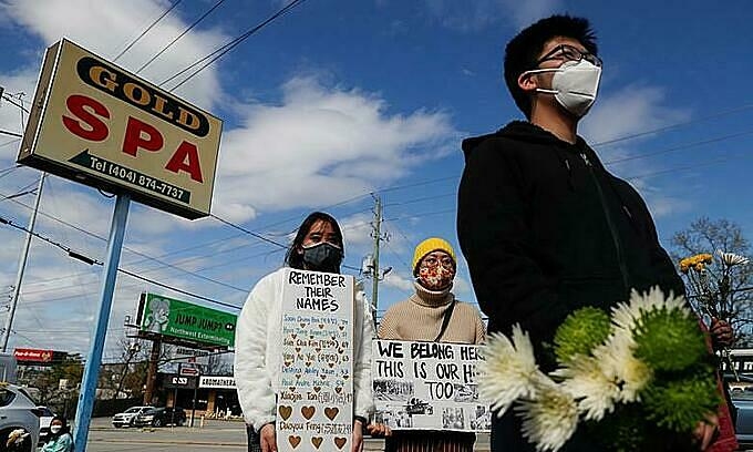 People hold placards during a vigil at a makeshift memorial outside the Gold Spa following the deadly shootings in Atlanta, Georgia, U.S. March 21, 2021. Photo by Reuters/Shannon Stapleton.