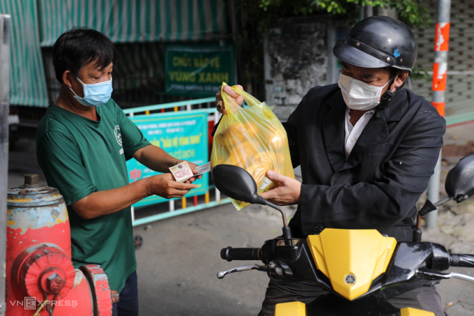 Hoang (R) buys seven banh mi for his family.  Most of the time we have banh mi, because it is convenient and cheap, said the 45-year-old.