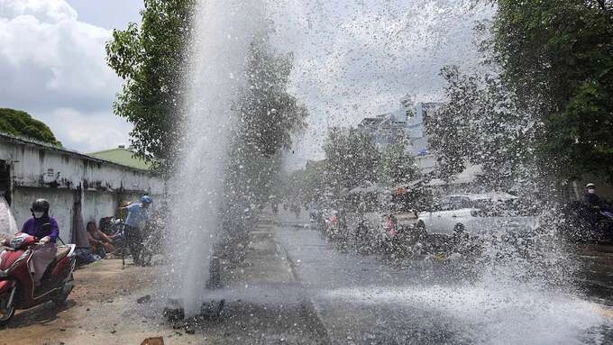 Water splashes all over the place after the car hits a fire hydrant on National Highway 22 in HCMCs District 12. Photo by VnExpress/Dinh Su