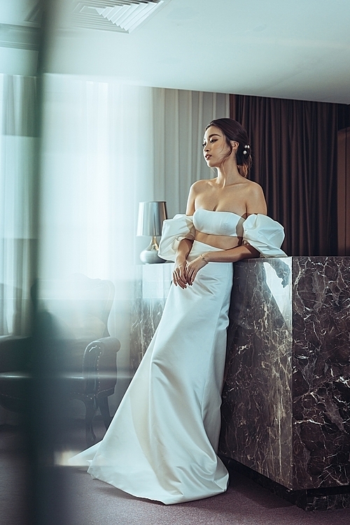 She poses with a duchess satin top and skirt with detachable sleeves.