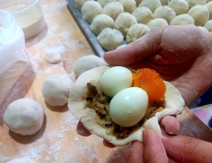 A pork pun is stuffed with two quail eggs and a steamed salted egg yolk. Photo by VnExpress/Khanh Thien