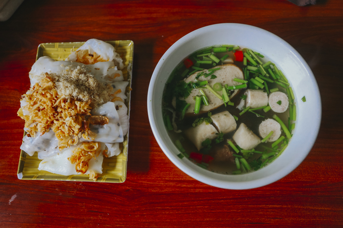 Rice rolls topped with pork floss and fried onions are served with a bowl of hot broth that contains sausages, herbs and chili. Photo by VnExpress/Xuan Phuong