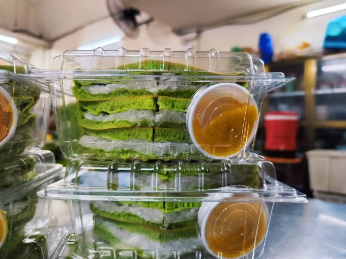 Coconut cakes are cut into smaller pieces and placed in a plastic container when purchased. Photo courtesy of Banh dua Tan Da