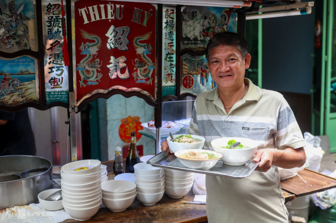 Duong Huy in front of his shops noodle cart. Photo by VnExpress/Quynh Tran