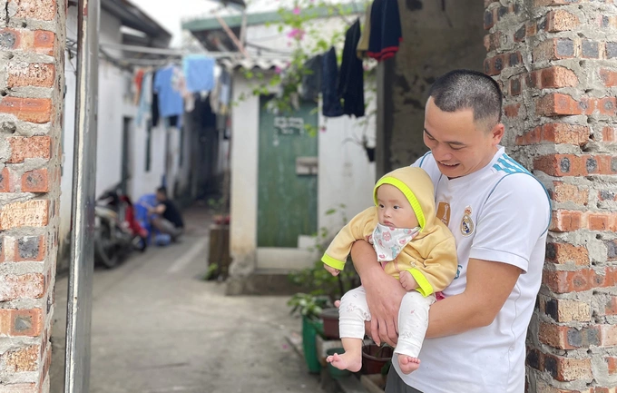 Tran Do with his eight-year-old daughter in front of his house in Hanois Dong Anh District, March 8, 2023. Photo by Phan Duong