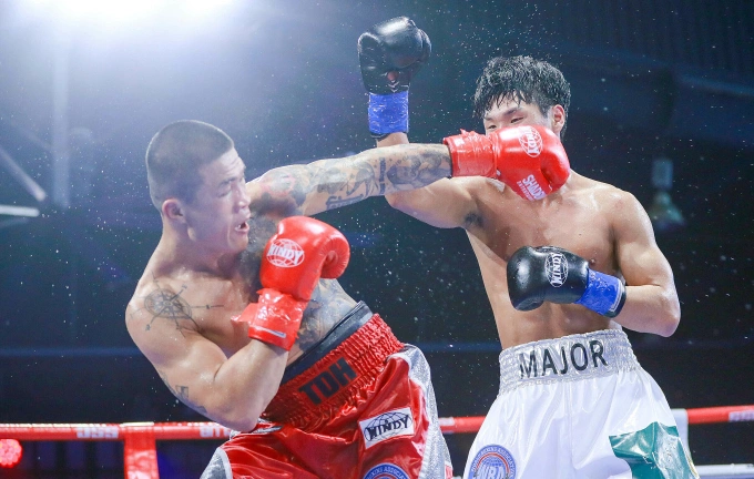 Truong Dinh Hoang (L) throws a left hook at Dae Hyun-baek in the WBA Asia super middleweight title match on March 25, 2023. Photo by VnExpress/Quang Liem