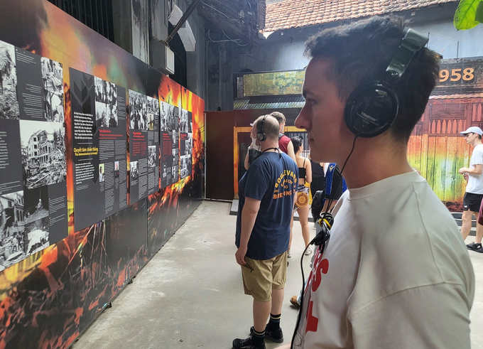 Philip, a German living in Hanoi, wears a headphone as he listens to an automatic narrative at Hoa Lo Prison Relic, May 2, 2023. Photo by VnExpress/Anh Tu