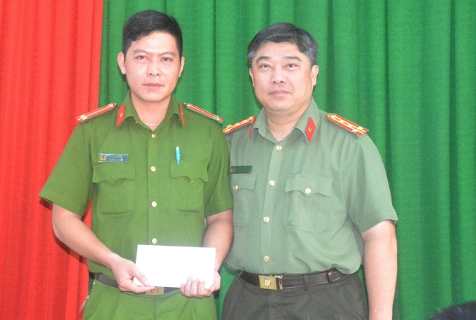 Lieutenant Tran Nhat Duy (L) is praised by Colonel Le Hoai Phong at Tan Binh Districts Police Department, May 11, 2023. Photo by VnExpress/Nhat Vy