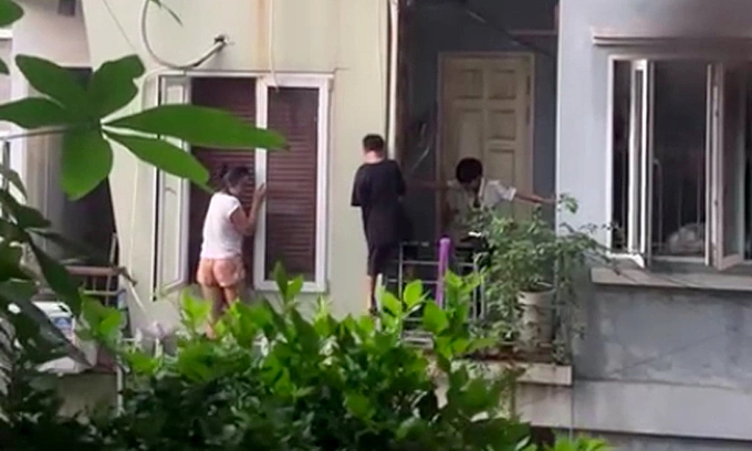 A still from video footage shows a family in Hanoi escaping a house fire through the balcony. Photo obtained by VnExpress