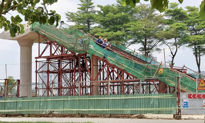 Workers build an overpass that will link with an elevated station of HCMCs metro line No.1 in front of the Saigon Hi-Tech Park in Thu Duc City, May 2023. Photo by VnExpress/Gia Minh