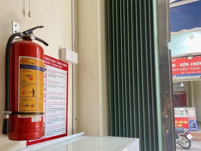 A family in Hoan Kiem District, Hanoi, equips themselves with domestic fire extinguishers after experiencing a house fire that almost killed four members of the family in 2022. Photo by VnExpress/Phan Duong