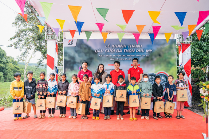 Sponsors give gifts to local students in difficult circumstances on the occasion of the bridge inauguration. Photo by Bridgestone Vietnam