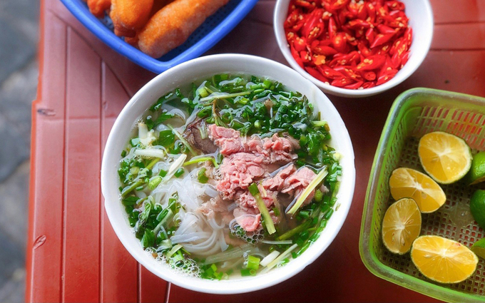 Eye-round steak noodle soup is another variant of the famous beef noodle soup in northern Vietnam. This version features tender pieces of beef, thinly sliced and boiled.The ingredients for this dish include broth made from beef and pork bones, ginger, onions, fish sauce, sugar, star anise, cloves, cinnamon, and cardamom. After placing the noodle soup and beef in the bowl, the broth is poured over, and a garnish of green onions is added. Lime is often provided on the side for diners who prefer a tangy kick. Photo by Quynh Mai