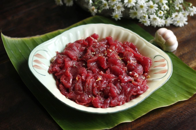 The sliced beef has a vivid red color and is thoroughly marinated with various seasonings. Photo by VnExpress/Bui Thuy