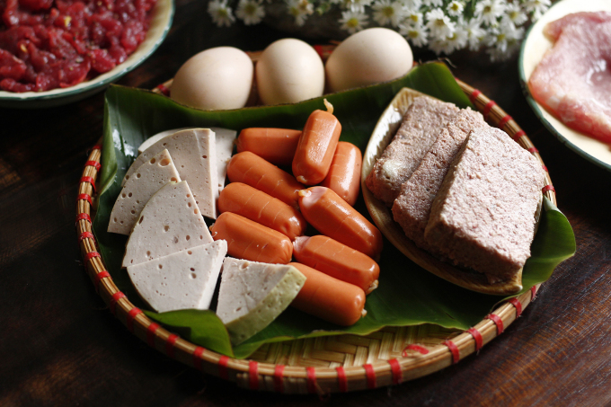 The dish includes a variety of savory toppings, including eggs, pate, sausages, pork rolls. Photo by VnExpress/Bui Thuy