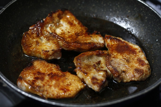 The pork chops sizzle to a perfect golden brown. Photo by VnExpress/Bui Thuy