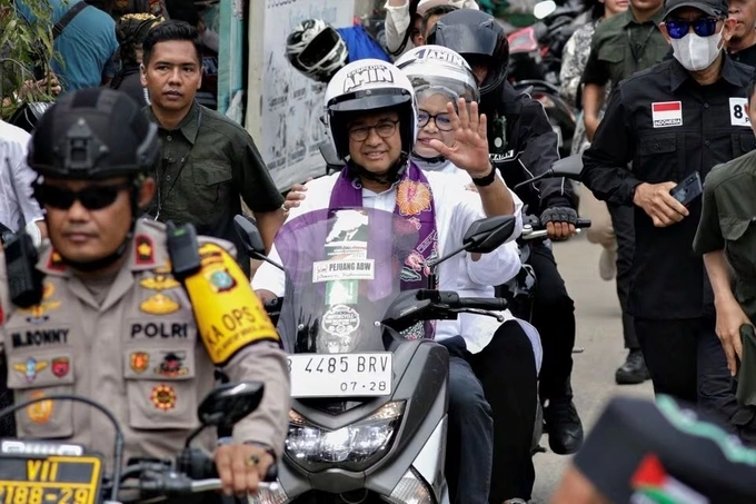 Anies Baswedan rides a motorcycle with his wife Fery Farhati before his campaign in Jakarta, Indonesia, Nov. 28, 2023. Photo by Reuters