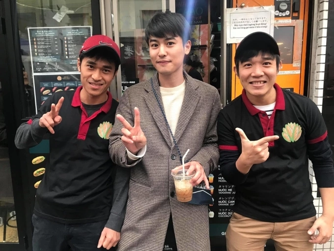 Bui Thanh Tam (R) and his brother Bui Thanh Duy (L) pose with a Japanese customer at their Banh mi Xin Chao sandwich shop. Photo courtesy of Tam and Duy