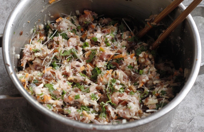 Mixing the meat and veggies together yields a thick mixture. Photo by VnExpress/Bui Thuy