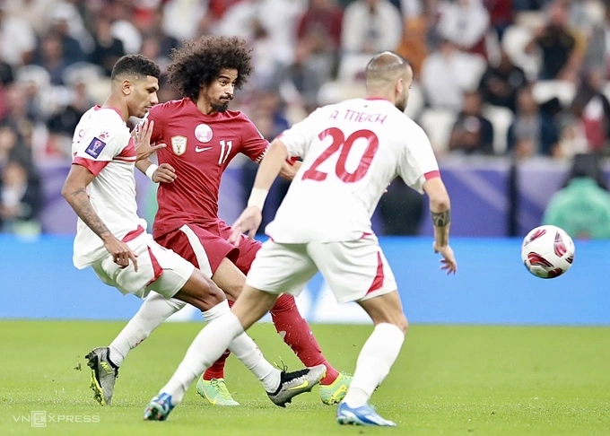 Akram Afif (C) moves between two Lebannon players in Qatars opening game at the 2024 Asian Cup, Jan. 12, 2024. Photo by VnExpress/Lam Thoa
