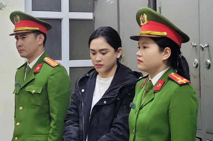Two officers escort Phan Thi Ngoc Minh to a police station in Ha Tinh Province, January 14, 2024. Photo by police
