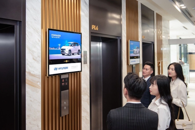 People pay attention to media content while waiting for the elevators. Photo courtesy of Chicilon Media