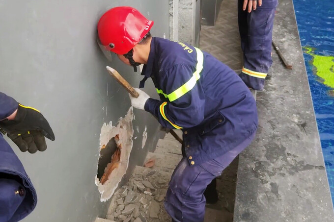 A soldier breaks a wall of a hotel in Nha Trang City to save two Chinese men stuck in an elevator, Jan. 20, 2024. Photo by police