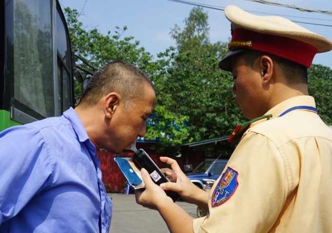 A police officer checks the alcohol level in the breath of a driver in Hanoi. Photo by VnExpress/Gia Chinh