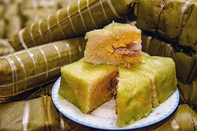 Once cut, banh chung reveals a contrasting light color against its dark green exterior (a product of the banana leaves it’s wrapped in). Photo by VnExpress/Thanh Hue
