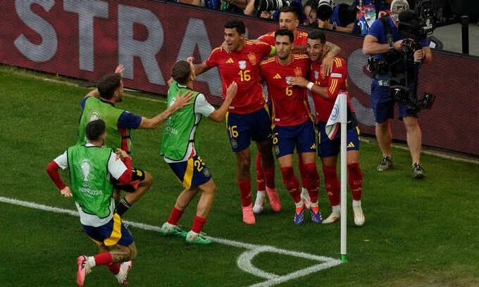 Spains Mikel Merino (number 6) celebrates with teammates after scoring his sides second goal during a quarter final match between Germany and Spain at the Euro 2024 football tournament in Stuttgart, Germany, July 5, 2024. (AP Photo/Michael Probst)
