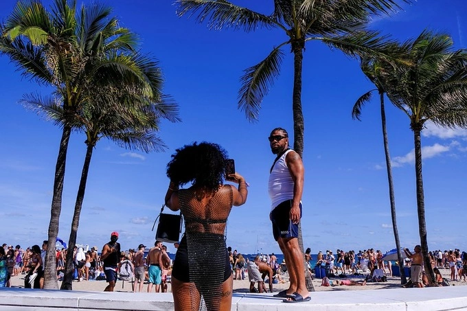 A woman takes a photo in front of the beach as spring break begins in Fort Lauderdale, Florida, March 5, 2021. Photo by Reuters