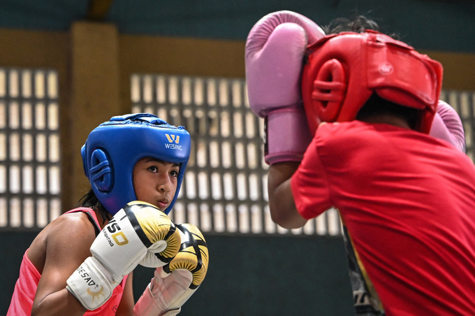 This photo taken on June 5, 2024 shows Prystine Niche Cantancio (L) sparring during training at a boxing gym in Bago City, Negros Occidental province. Photo by AFP