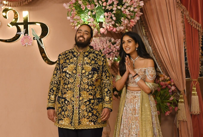Anant Ambani (L), son of Indian businessman Mukesh Ambani, and his fiancée Radhika Merchant pose for a photo on the red carpet during the sangeet ceremony at Jio World Centre in Mumbai. Photo by Reuters