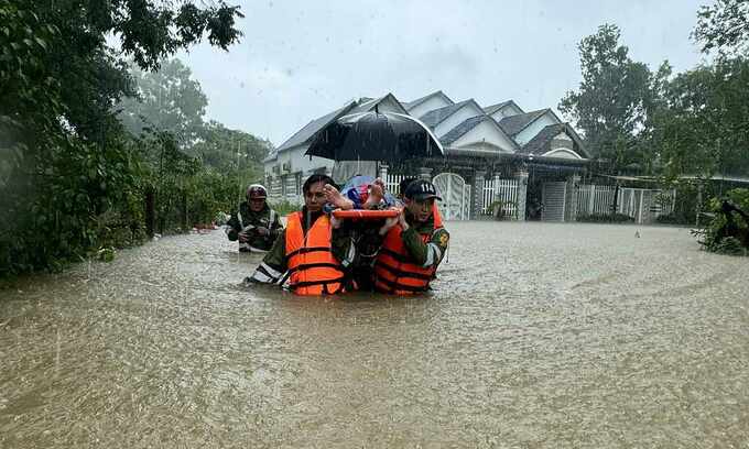 Soldiers wade through a flooded street on Phu Quoc Island to carry a patient to a local hospital, July 14, 2024. Photo by VnExpress/Duong Dong