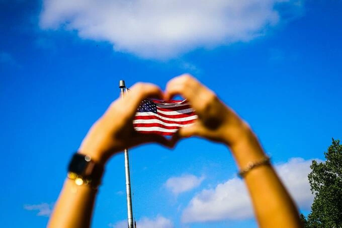 Human hands and the flag of the U.S. Illustration photo by Pexels
