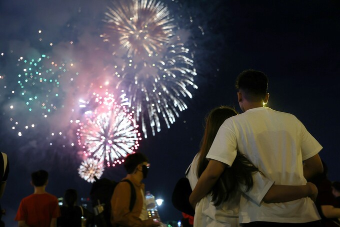 A couple watches a firework display to celebrate a new lunar year in downtown HCMC, January 23, 2023. Photo by VnExpress/Quynh Tran