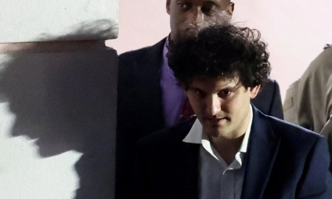 Sam Bankman-Fried, who founded and led FTX until a liquidity crunch forced the cryptocurrency exchange to declare bankruptcy, is escorted out of the Magistrate Court building after his arrest in Nassau, Bahamas December 13, 2022. Photo by Reuters
