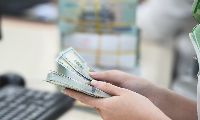 Dollar edges lower against dong