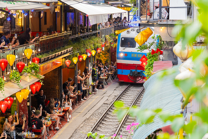 Tourists use their smartphones to capture images of a passing train at Hanois Train Street, November 2024. Photo by VnExpress/Hoang Giang