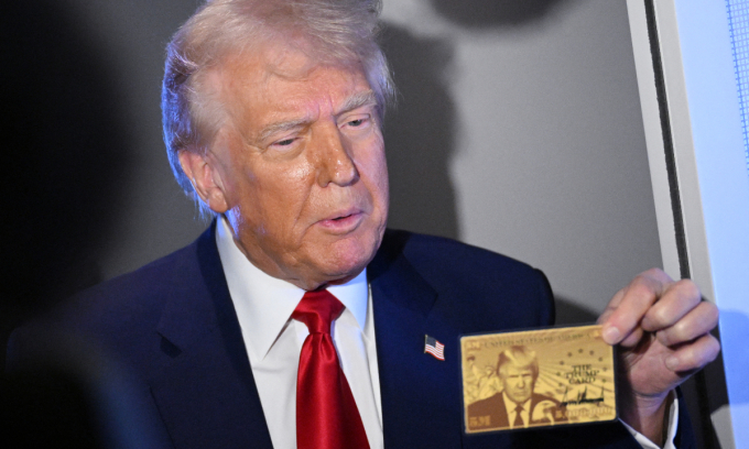 US President Donald Trump holds the $5 million dollar Gold Card