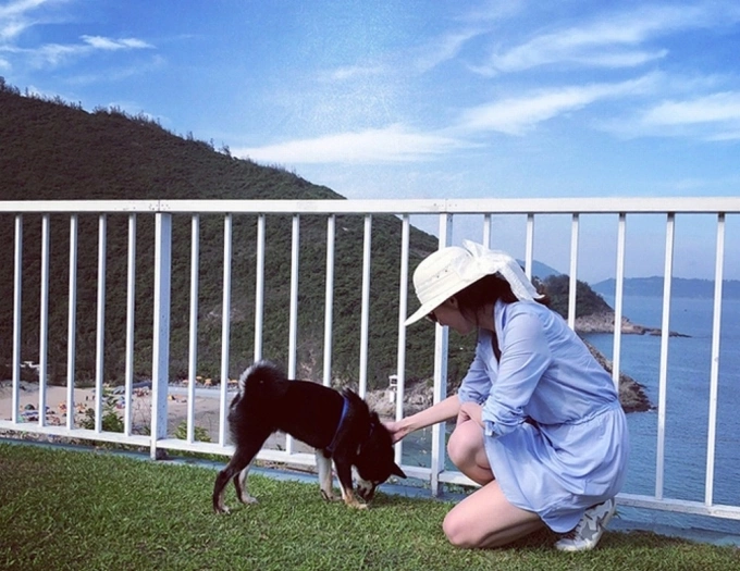 Michelle Reis plays with her pet at her villa with a sea view in the background. Photo from Weibo