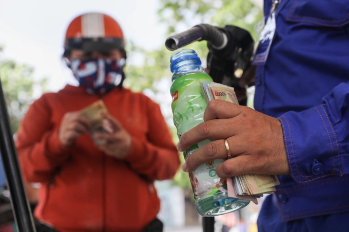 An employee fills a bottle with gasoline at a fuel station in Ho Chi Minh City in 2022. Photo by VnExpress/Quynh Tran