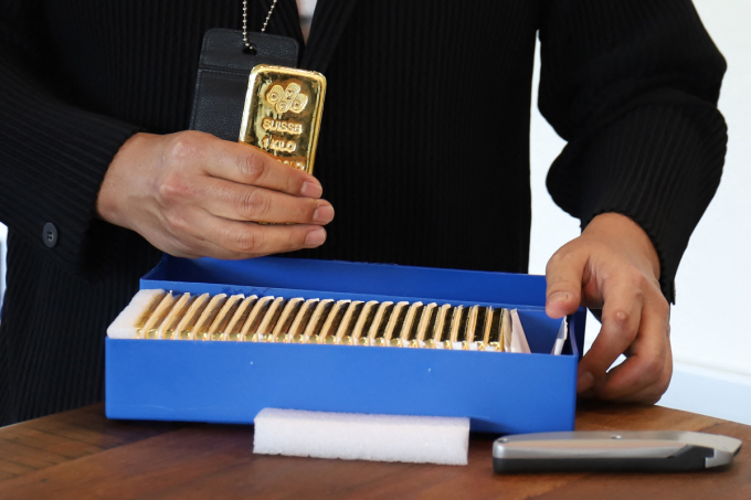 A person shows a box of gold bars in Singapore in 2020. Photo by AFP